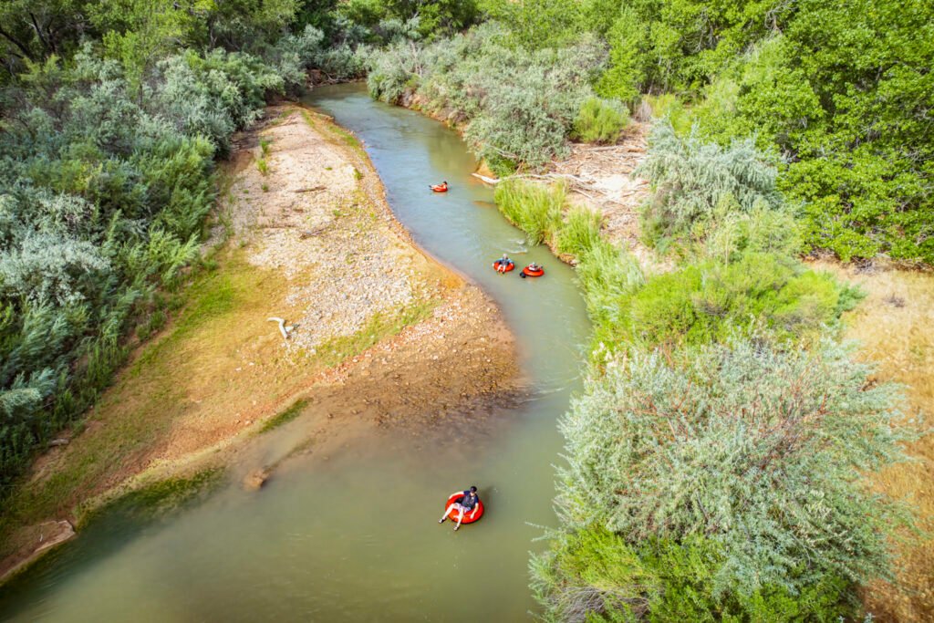 Serene view of tubers floating down the Virgin River in Zion National Park, Utah, surrounded by lush greenery and natural beauty